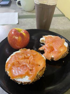 Lightly toasted everything bagel spread with cream cheese topped with cold salmon. That's a raspberry mocha iced coffee.