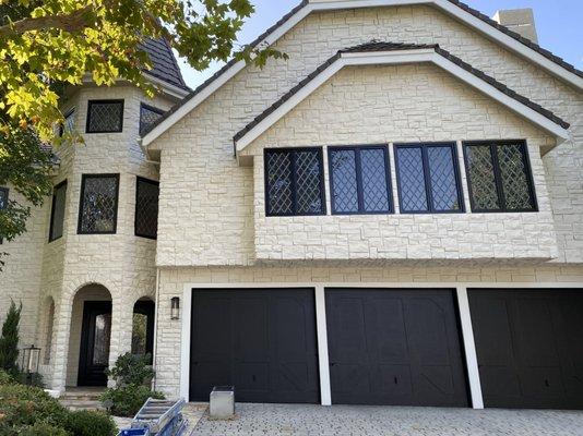 Painted garage doors, window trim, and front door black. Also white washed the stone.