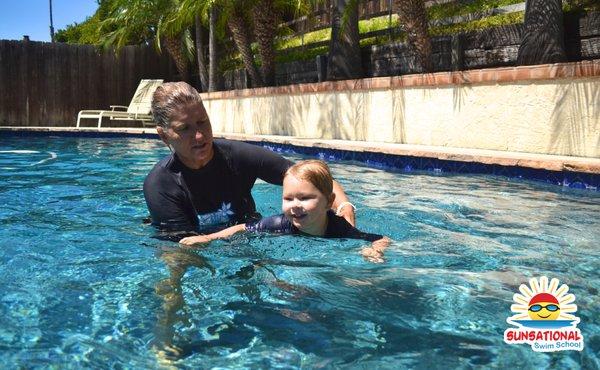 Baby swim lessons - student practices finding the nearest pool exit