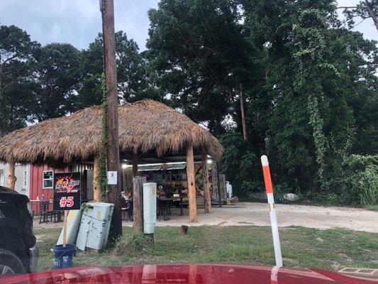 Outside seating under a thatched awning. You can order from your car.