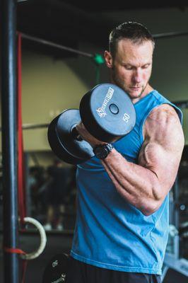 Josh Curtman (head trainer) getting a couple curls in between training clients.