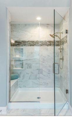 Handsome shower with custom glass featuring a simple composite base.