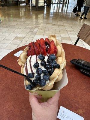 Bubble waffle with vanilla ice cream and fruit with a chocolate drizzle