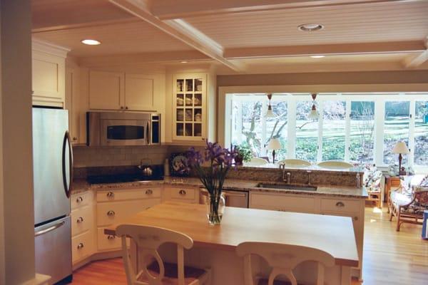 A dark poorly laid out kitchen gets a huge 12' opening in the exterior brick wall of a 2 story house into the existing sunroo...