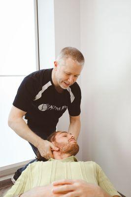 Dr. Dylan working on a patient's neck pain