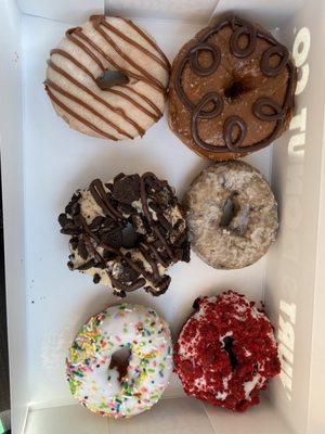 Jesús, salted caramel chocolate, peanut butter Oreo, blueberry glazed, sprinkles cake classic, red velvet   Top to bottom, left to right