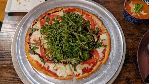 Margharita pizza on Cauliflower crust topped with arugula tossed in balsamic