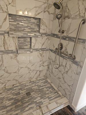 Custom shower build from framing to finish waterproofing with mosaic flooring and grab bars