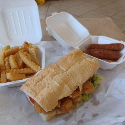 Shrimp po' boy with French fries and a piece of sausage. All came under twelve dollars.