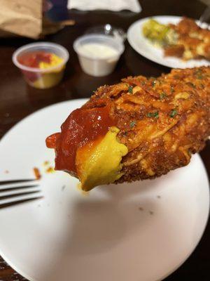 Hash brown corn dog served with ketchup and mustard