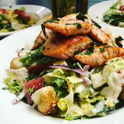 Our Top selling salad Grilled Salmon Caesar salad with tomato & onion and creamy Caesar dressing