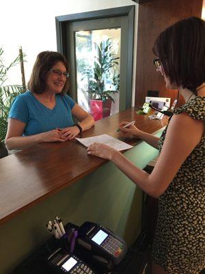 Friendly front desk staff helping a patient