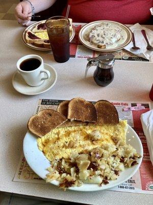 From bottom to top: home fries, cheese omelet, dark, dry rye, SOS, scrambled eggs.