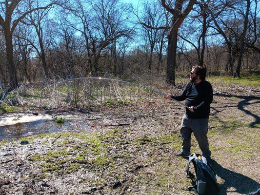 Disc golf course. Feb 2024.  Fishing for his disc.