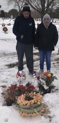 My older brother and my mother Standing over my grandmas gravesite Visiting Are love one