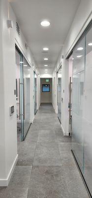 Bright, open hallway with dental rooms on each side with large LED monitors to watch tv or see your teeth xrays!