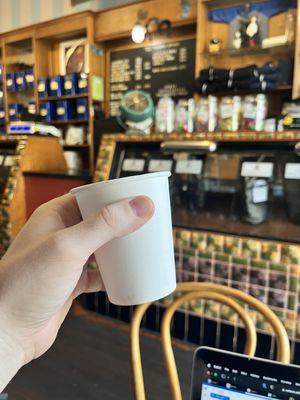 Perfectly balanced, custom espresso drink with the shop in the background