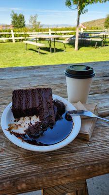 Chocolate cake w chocolate sauce and a coffee.