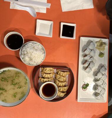 miso soup, side of steamed rice, crispy pork gyoza, california roll and spicy tuna roll.