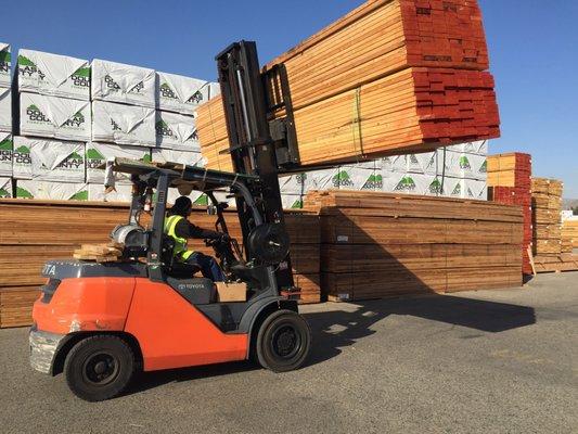 Custom orders of lumber being loaded on client trucks.