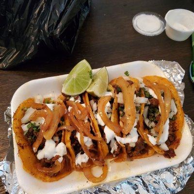 Steak Tacos with cooked onions and crema