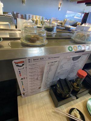 Sushi rolls and desert come by on a conveyer belt They are coded $2.95- $4.75 good prices