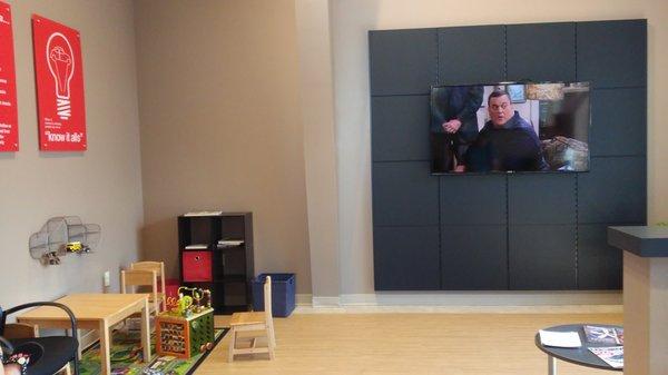 Big screen TV and play area in the waiting room.