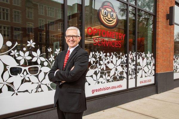 Dr. Greg Nixon, Associate Dean for Clinical Services stand in front of our Optometry Services window front for our new clinic.