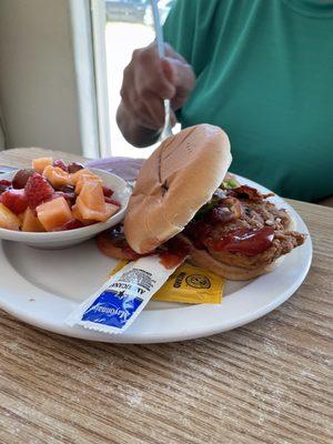 Chicken sandwich with fruit side.