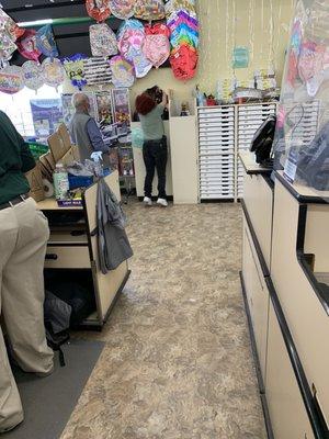 The employee to the left was the only one that was working the register. The employee at the balloons was making