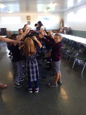 Giving blessings to the bag lunches the children prepared for St. Vincent DePaul.