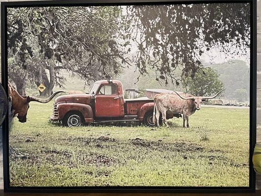 Photo of canvas. Green of grass, red of truck door, and darkness of tree limbs in upper right are all faded from original.