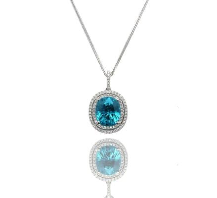 Oval blue zircon pendant with diamond double halo.