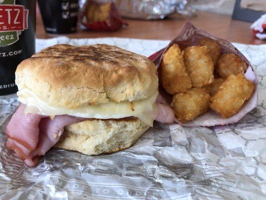 @bigmovie // Ham, egg and Swiss on a biscuit with tater tots