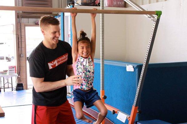 Bar hangs to practice grip strength for higher level bar skills.