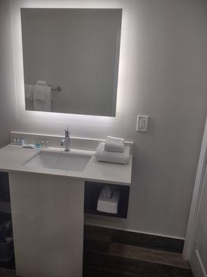 Mirror,and sink area, on the left they have cubby with the hairdryer and on the other side it has tissue's a pool towel and washcloth.