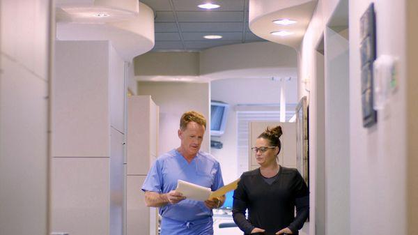 Spokane dentist Dr. Robert Walker and dental hygienist discussing dental implants case in the hallway at Cascade Dental Care South Hill