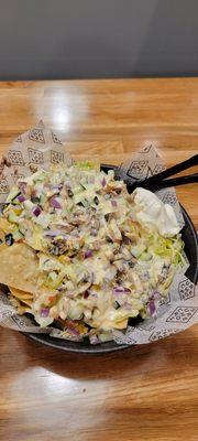 Nachos loaded with chicken, onions, cucumbers, jalapeños, mushrooms, rice, black beans, and questions.