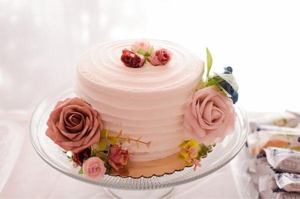 Plain textured white cake with fresh strawberries filling. The flowers were added by my sisters.