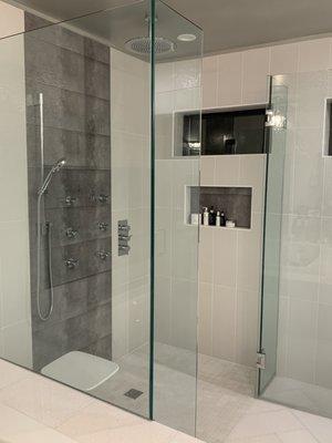 Master Bathroom universal ADA design roll in shower with folding bench. Full tile floor to ceiling. Glass shower