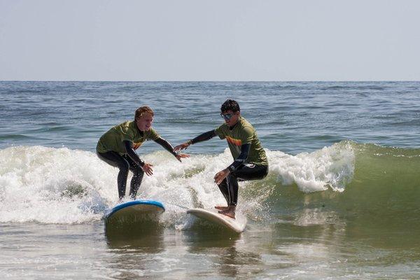 Instructors Bailey and Jeyner share a wave to ride out the day's work teaching at camp.