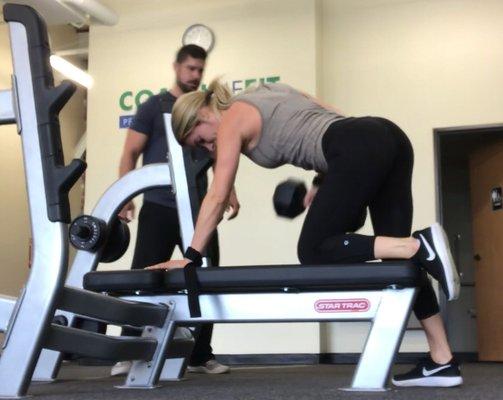 Pictured here is Head Coach Derek coaching Amanda through a one arm Dumbbell row.