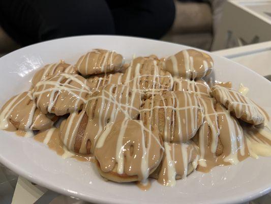 Freshly-made tiny pancakes drizzled with gooey caramel-like topping