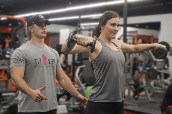 Coach Daniel and Alexis with lateral raises.