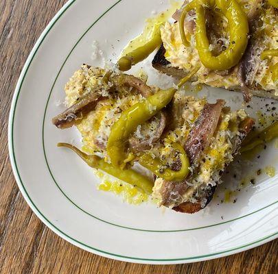 Egg and green olive toast with anchovy and piparra peppers