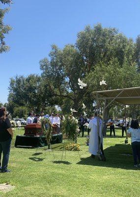 Graveside with white doves