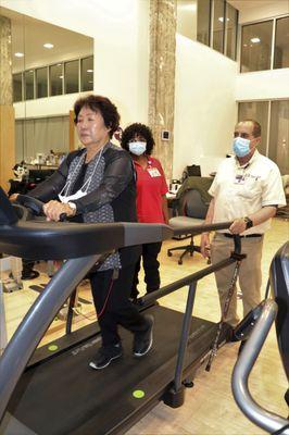 With physical therapists standing by, participant walks on the treadmill.