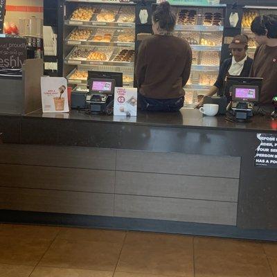 Employee sitting on the front counter during business hours. Unsanitary and unacceptable.