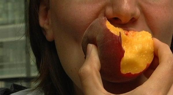 Eating a peach at Slow Food Chicago Event. Still from SFC Eat-In video