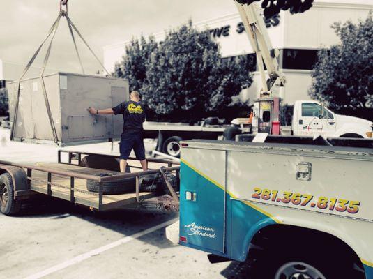 Scott lowering the old rooftop unit onto our trailer.